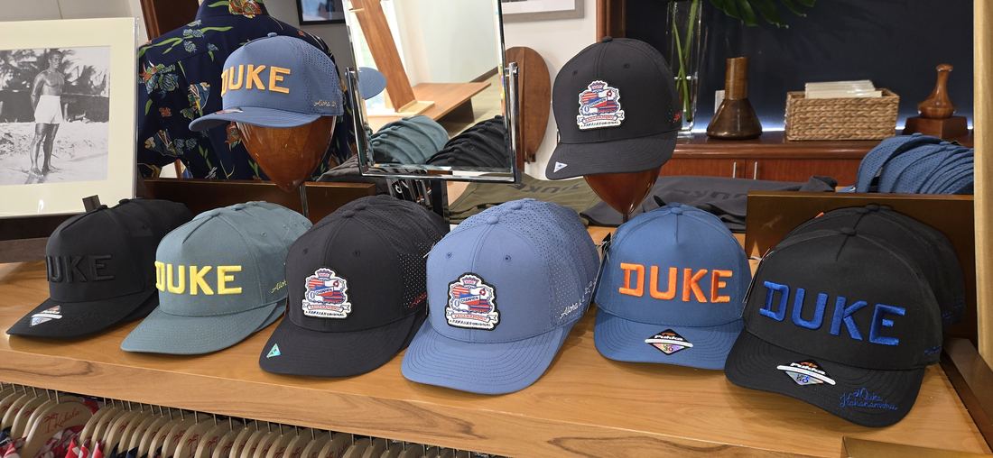 Duke caps in a row on a wooden counter.