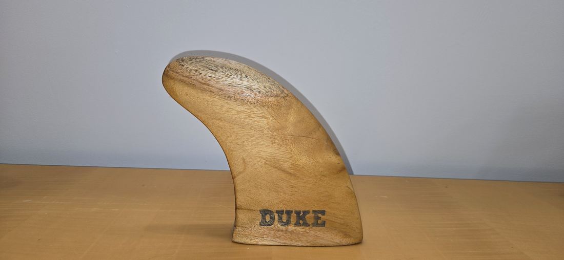A hand-carved wooden fin, marked DUKE.