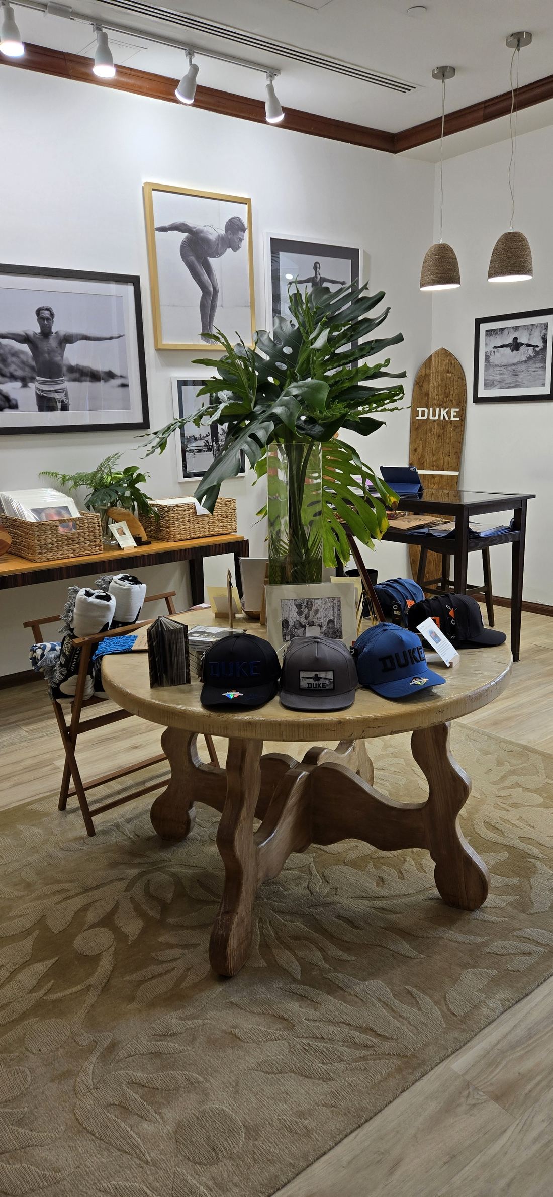 The round table and the monstera, with photographs of Duke on the wall.